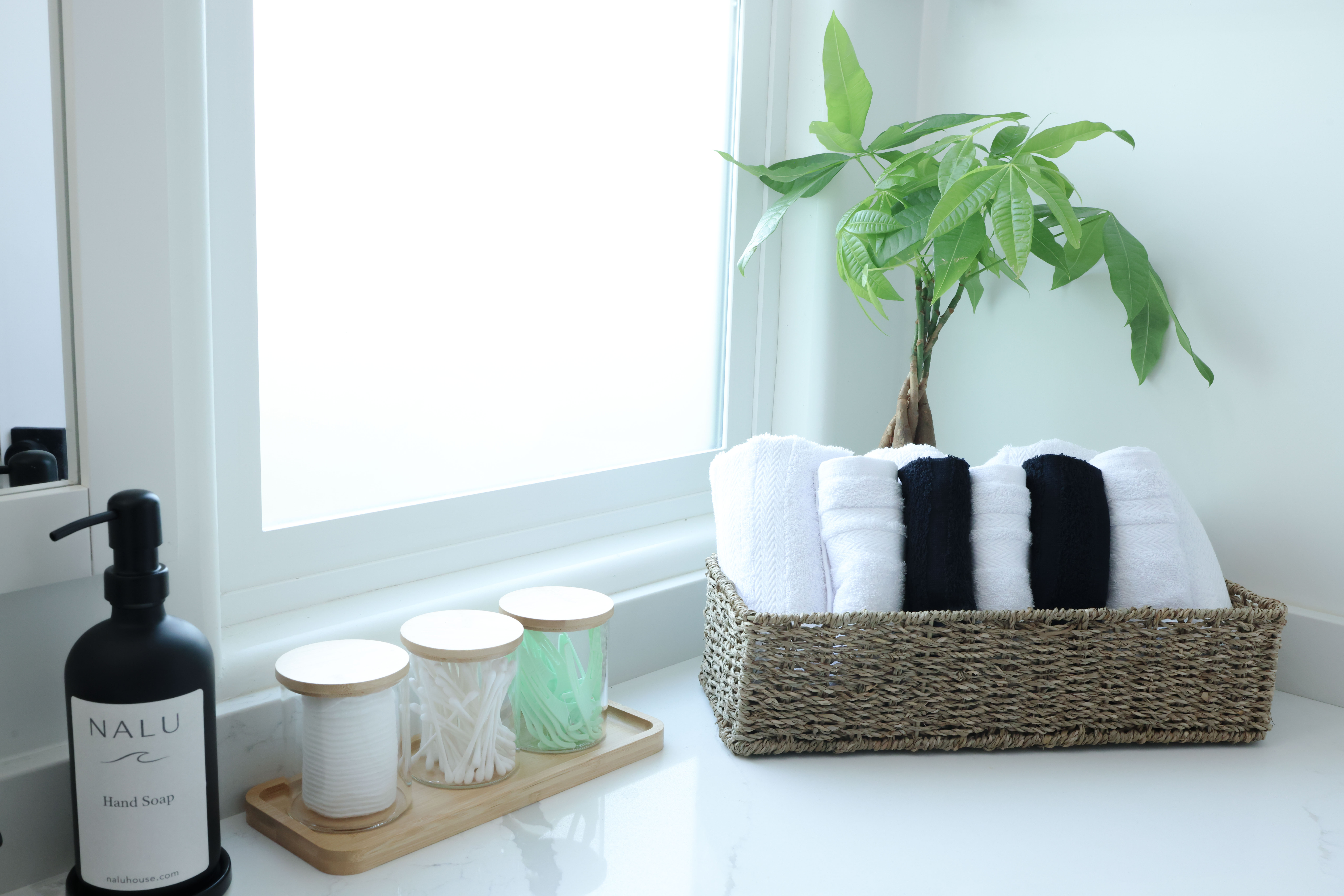 Bathroom vanity detail with Nalu hand soap and rolled towels