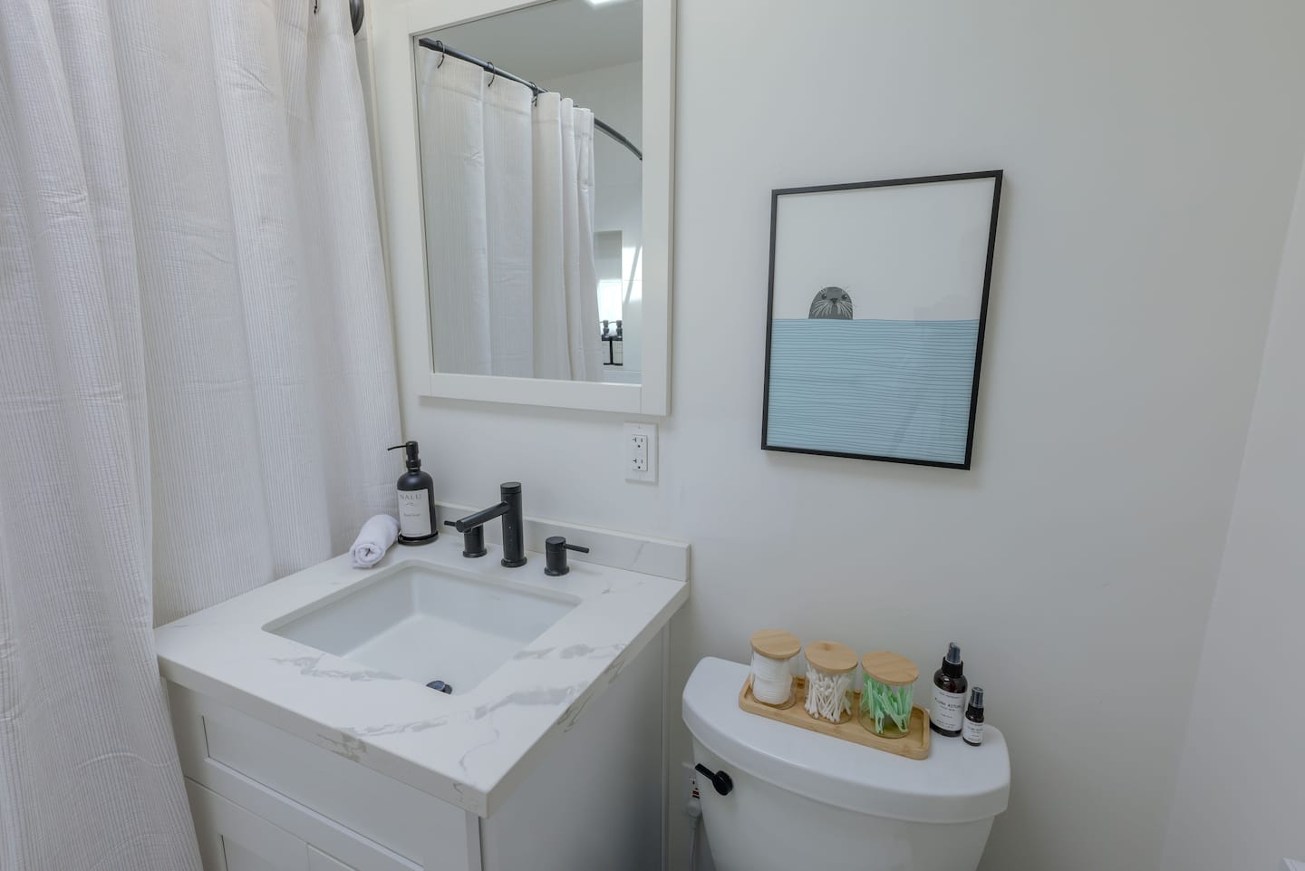 Light-filled bathroom with white finishes and natural accents