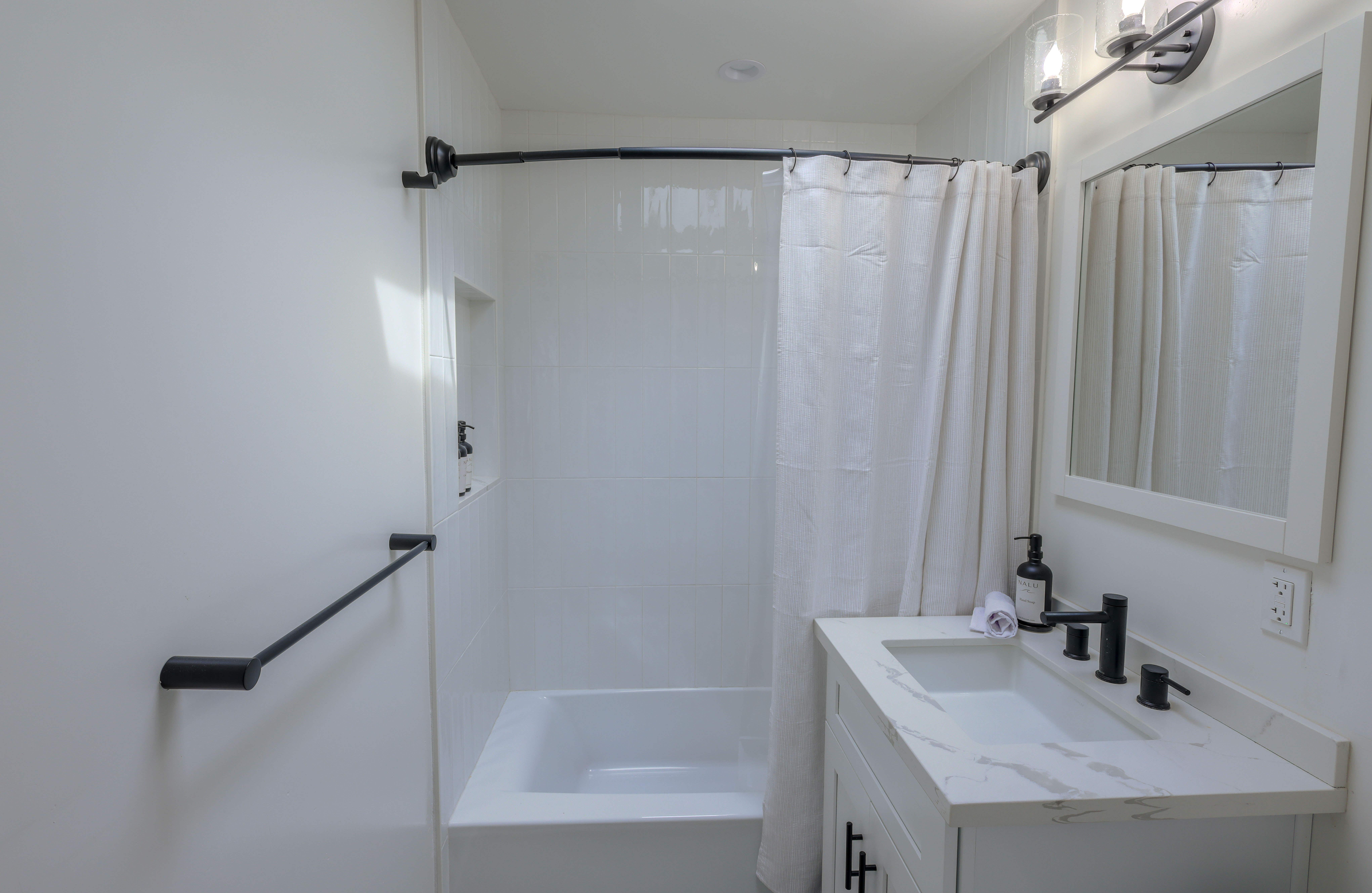 Light-filled bathroom with white finishes and natural accents