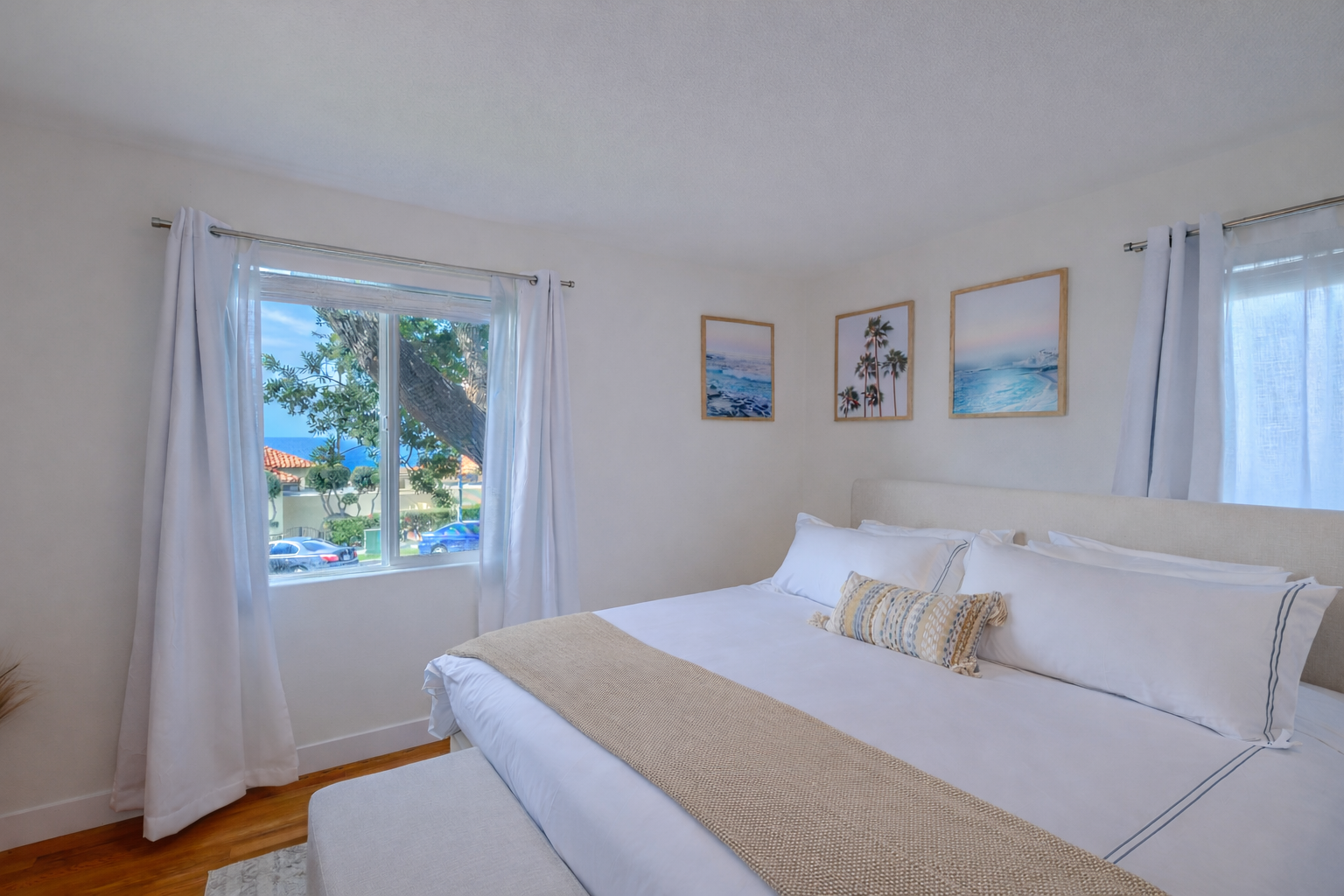 Bedroom with a king bed, textured wall art, and warm wood floors