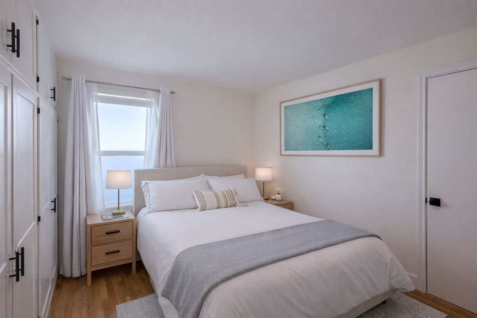 Bedroom with queen bed and aerial surf artwork