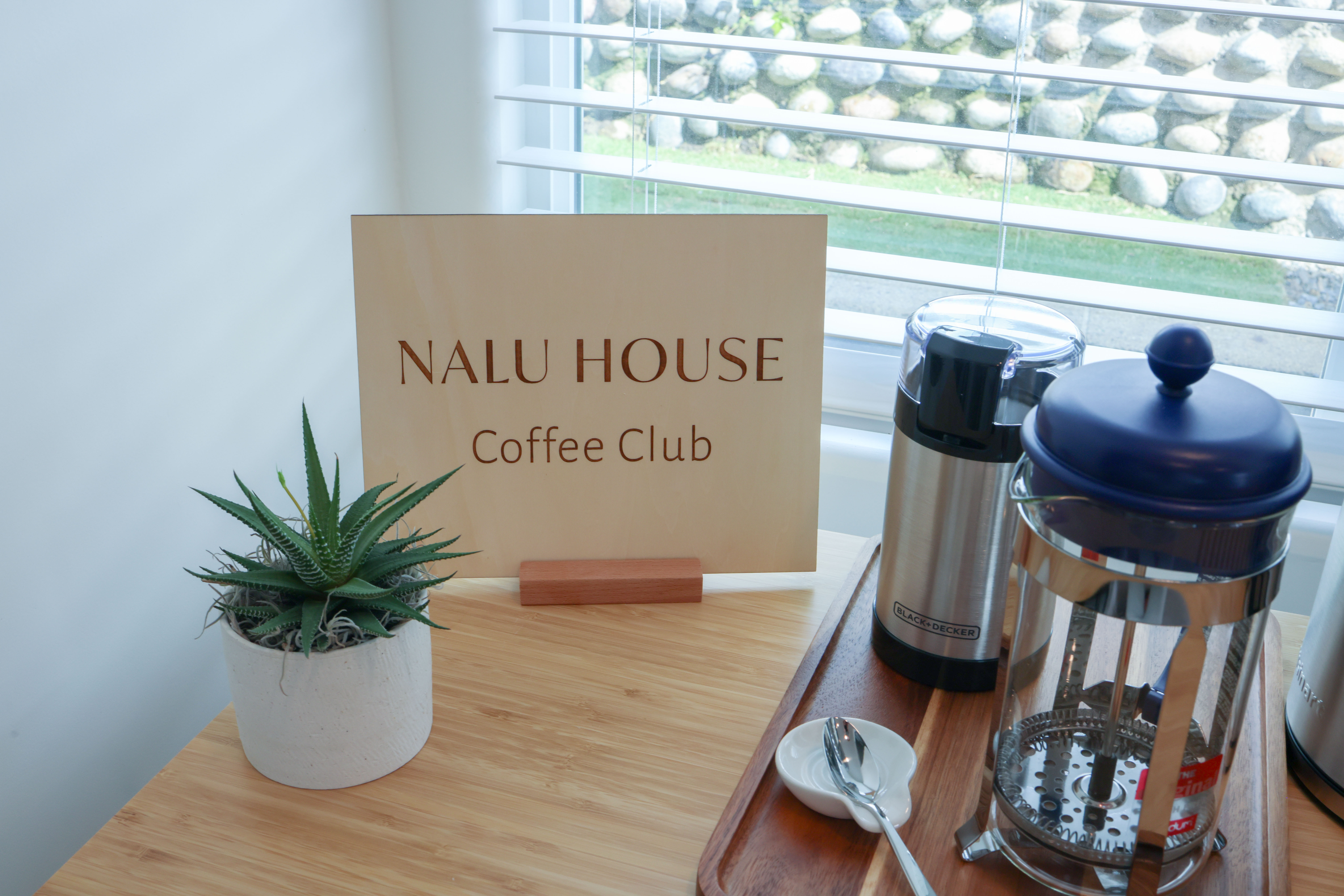 Coffee bar with warm wood and a calm coastal palette