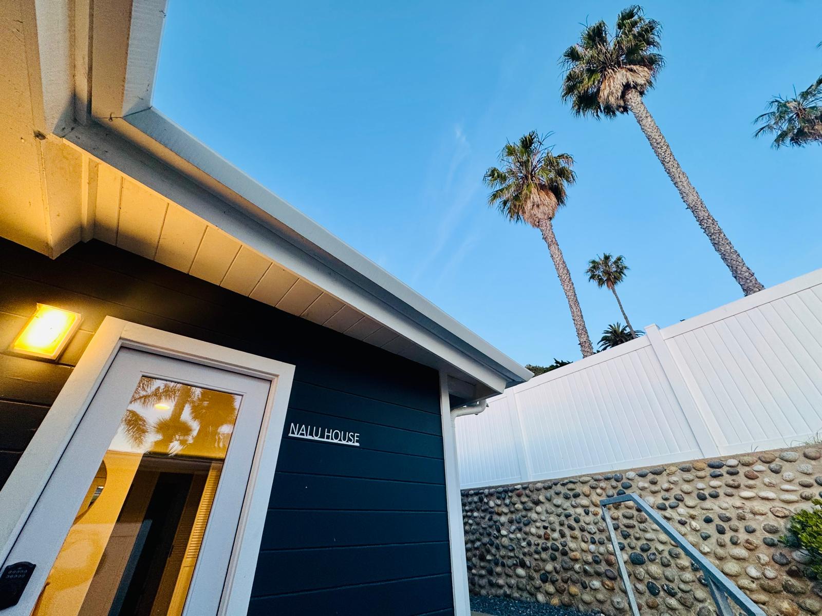 Nalu House entrance with palm trees against a blue La Jolla sky
