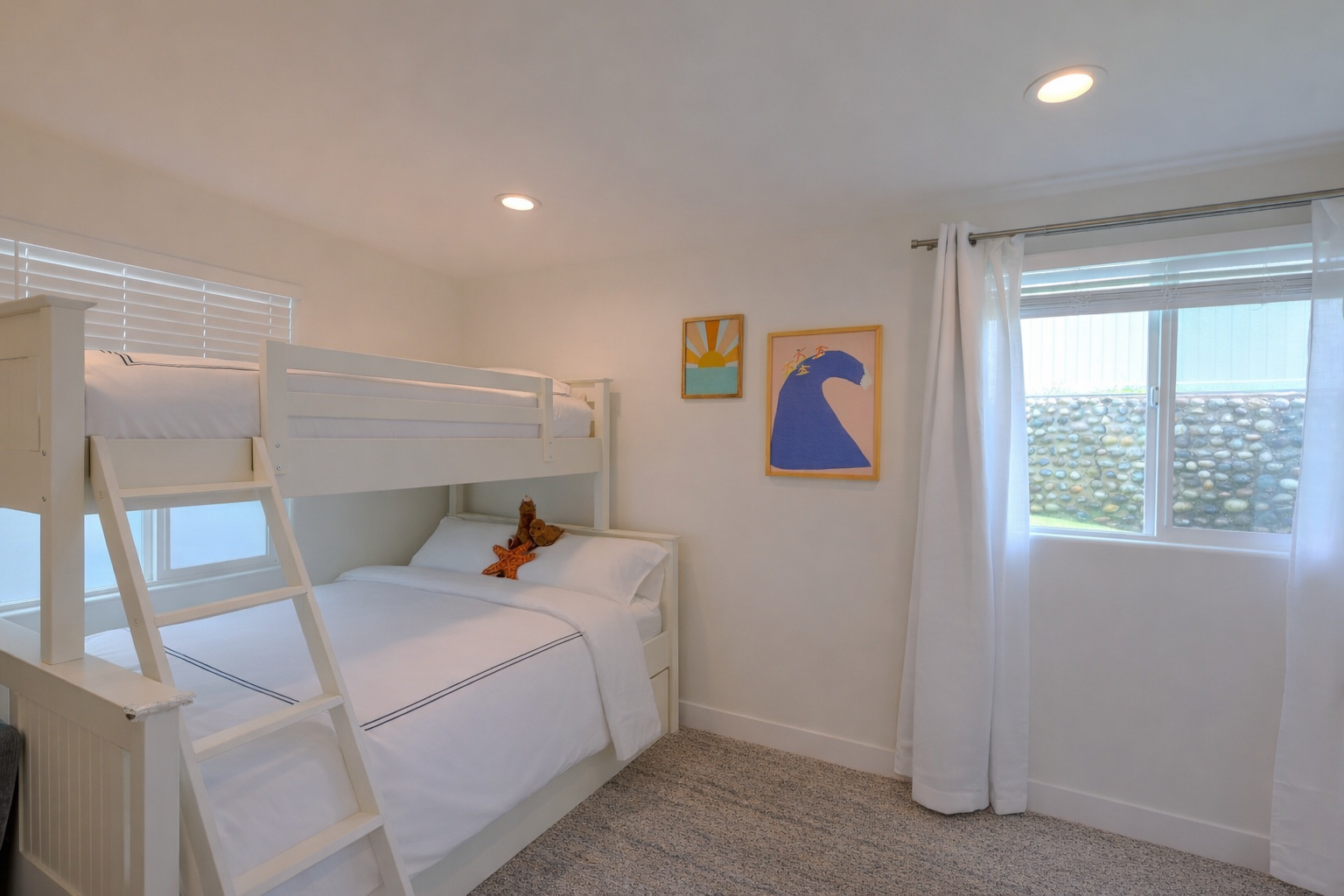Family bunk room with a twin-over-full bunk bed, a crib, and playful coastal prints