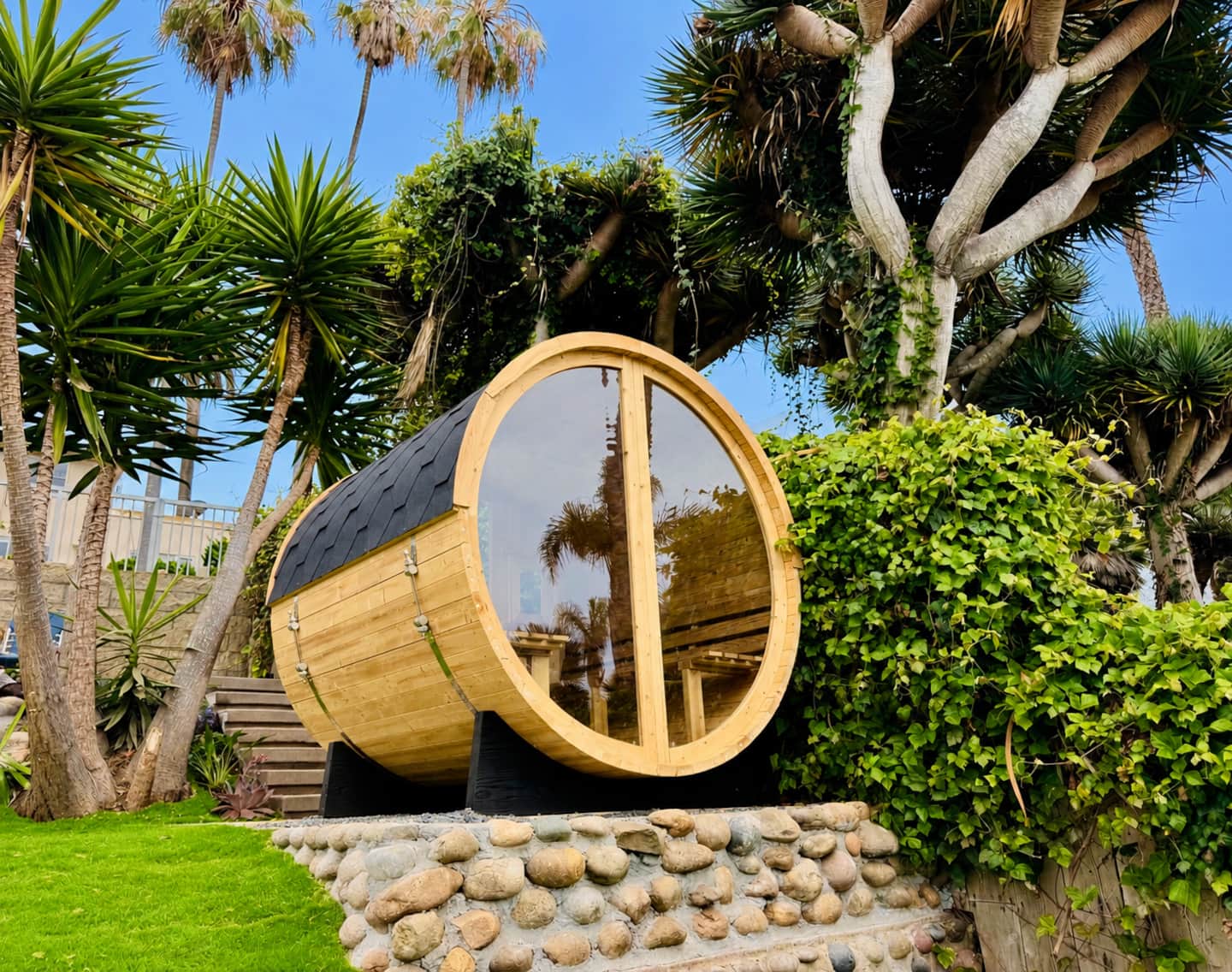 Cedar barrel sauna tucked into the palm-filled backyard